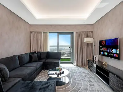a living room with a couch and a tv at Sky-high 1Br Apartment Sleeps 4 in Damac Paramount in Dubai