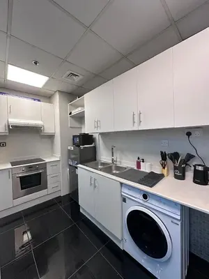 a kitchen with white cabinets and a sink and a dishwasher at Marina Beach JBR 1BR Apartment in Dubai Marina in Dubai