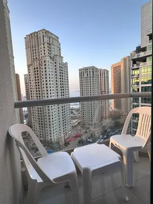 a balcony with two chairs and a view of a city at Marina Beach JBR 1BR Apartment in Dubai Marina in Dubai