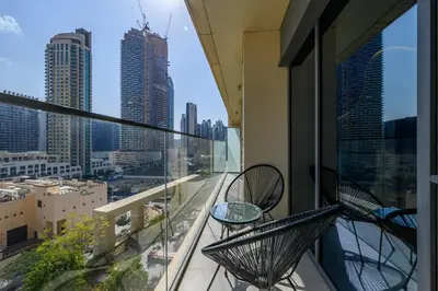 a balcony with two chairs and a view of a city at Downtown Suite Trendy 1BR -Dubai Mall Access in Dubai