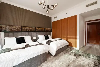two beds in a bedroom with a wall at Coastal Elegance with PlayRoom PS5, 4BHK front JBR Beach Sleep 14 pax in Dubai