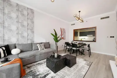 a living room with a couch and a table at Coastal Elegance with PlayRoom PS5, 4BHK front JBR Beach Sleep 14 pax in Dubai