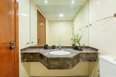 a bathroom with a marble sink and a mirror at Coastal Elegance with PlayRoom PS5, 4BHK front JBR Beach Sleep 14 pax in Dubai