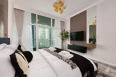 a bedroom with a large white bed with a large window at Coastal Elegance with PlayRoom PS5, 4BHK front JBR Beach Sleep 14 pax in Dubai