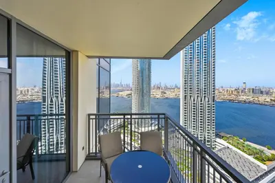 a balcony with a table and chairs and a view of the water at Creek Rise Tower 2 - 1BR with Creek Views, Panoramic Living, Dubai Creek Harbour in Dubai