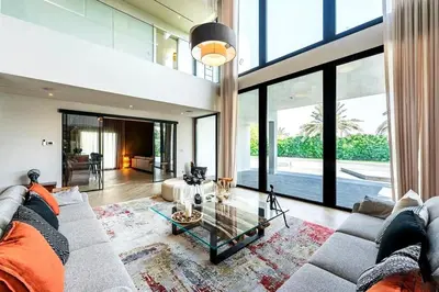 a living room with a couch and a glass table at Luxurious 4 Bedroom Villa In Emirates Hills in Dubai