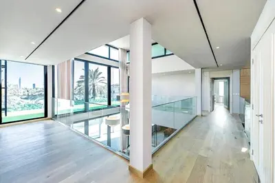 a room with glass walls and a hallway with a table at Luxurious 4 Bedroom Villa In Emirates Hills in Dubai