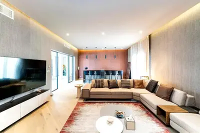 a living room with a couch and a tv at Luxurious 4 Bedroom Villa In Emirates Hills in Dubai