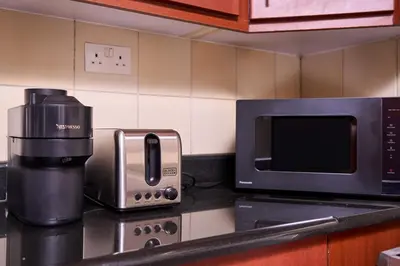 a kitchen counter with a coffee maker and a microwave at JBR 2BR with Iconic Palm Views Sadaf 6 Luxury in Dubai