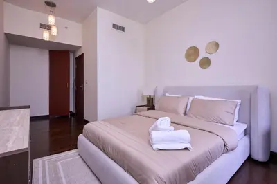 a bedroom with a large bed with a towel on it at JBR 2BR with Iconic Palm Views Sadaf 6 Luxury in Dubai