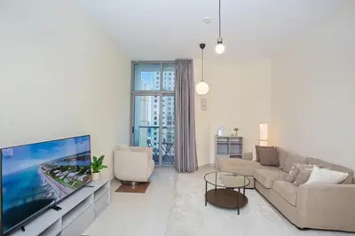 a living room with a large flat screen tv at Cozy 2 Bedroom Apartment with Balcony Near JBR Beach in Dubai