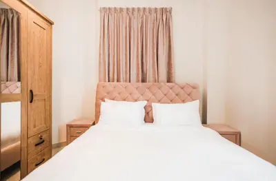 a bedroom with a bed with white sheets and a window at Cozy 2 Bedroom Apartment with Balcony Near JBR Beach in Dubai