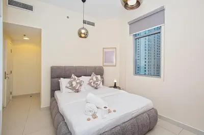 a bedroom with a large bed with white sheets and pillows at 2 Bedroom Apartment JBR Skyline with Balcony in Dubai