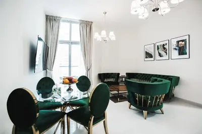 a dining room with a glass table and green chairs at 2 Bedroom Apartment JBR Skyline with Balcony in Dubai