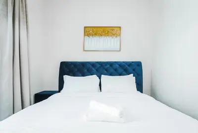 a bedroom with a bed with a blue headboard at 2 Bedroom Apartment JBR Skyline with Balcony in Dubai