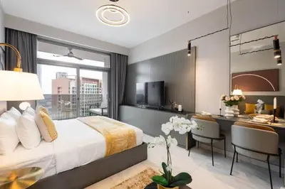 a hotel room with a bed and a desk and a kitchen at Vogue Downtown Mag 318 near Burj Khalifa and Dubai Mall, Studio Apartment with Balcony, Pool and City View, Access to all Amenities in Dubai
