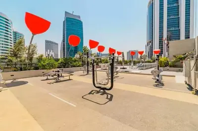 a parking lot with red umbrellas in a city at Vogue Downtown Mag 318 near Burj Khalifa and Dubai Mall, Studio Apartment with Balcony, Pool and City View, Access to all Amenities in Dubai
