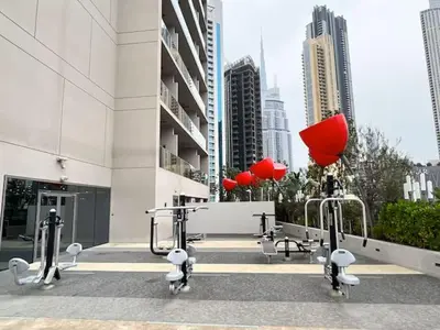 a building with fitness equipment in a city at Vogue Downtown Mag 318 near Burj Khalifa and Dubai Mall, Studio Apartment with Balcony, Pool and City View, Access to all Amenities in Dubai