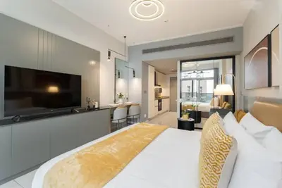 a large bedroom with a large bed and a kitchen at Vogue Downtown Mag 318 near Burj Khalifa and Dubai Mall, Studio Apartment with Balcony, Pool and City View, Access to all Amenities in Dubai