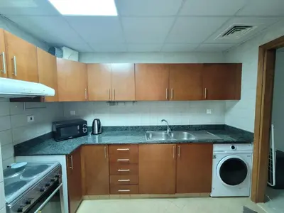 a kitchen with a sink and a washing machine at One Bedroom Apartment in Mag 214, JLT in Dubai