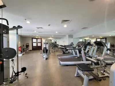a gym with lots of treadmills and machines at One Bedroom Apartment in Mag 214, JLT in Dubai