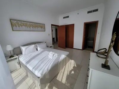 a bedroom with a bed with a white bedspread at One Bedroom Apartment in Mag 214, JLT in Dubai
