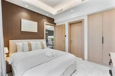 a bedroom with a large white bed and a mirror at Luxury 1 Bed Retreat with Balcony in JVT in Dubai