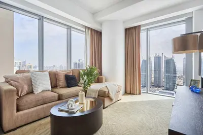 a living room with a couch and large windows at Frank Porter - Dubai Marina Mall Hotel in Dubai