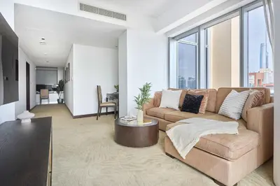 a living room with a couch and large windows at Frank Porter - Dubai Marina Mall Hotel in Dubai