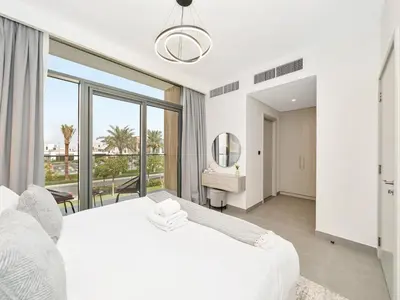 a bedroom with a white bed and a large window at Royal Vista 26 - 4BR Villa at Arabian Ranches III in Nadd Shubayḩ