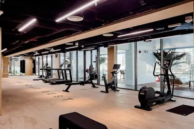 a gym with a lot of treadmills and ellipticals at Luxury 1BR Duplex on the Canal Business Bay in Dubai