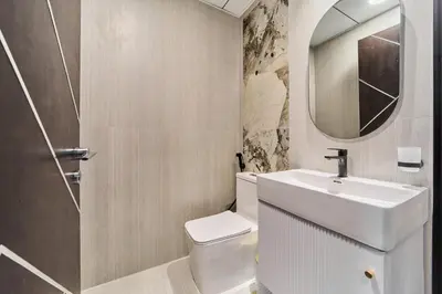 a bathroom with a sink and a toilet and a mirror at Elegant 2BR Retreat at Opalz Arjan in Dubai