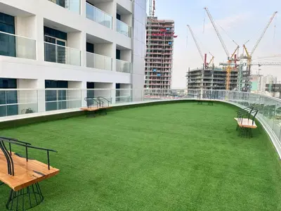 a large yard on the roof of a building with cranes at Elegant 2BR Retreat at Opalz Arjan in Dubai