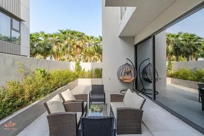 an outdoor patio with wicker chairs and a table at Spacious 4 Bed Villa with Private Pool and Meydan in Dubai