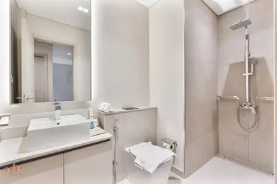 a white bathroom with a sink and a shower at Spacious 4 Bed Villa with Private Pool and Meydan in Dubai