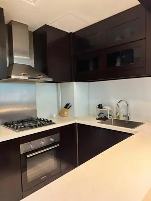 a kitchen with black cabinets and a stove top oven at Damac Upper Crest 2BR Dubai Mall Near 5 min walk in Dubai