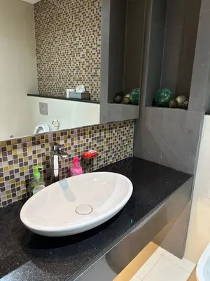 a bathroom with a white sink in a black counter at Damac Upper Crest 2BR Dubai Mall Near 5 min walk in Dubai