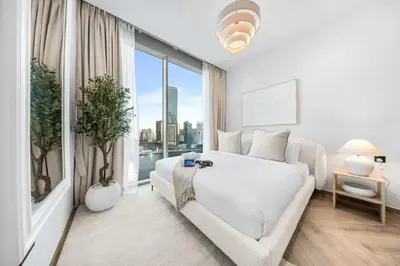 a bedroom with a white bed and a large window at Stayshort - 1 Bedroom in Business Bay with Canal Views that Sleeps 4 in Dubai