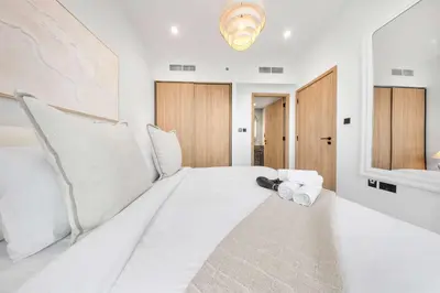 a bedroom with a large white bed with towels on it at Stayshort - 1 Bedroom in Business Bay with Canal Views that Sleeps 4 in Dubai