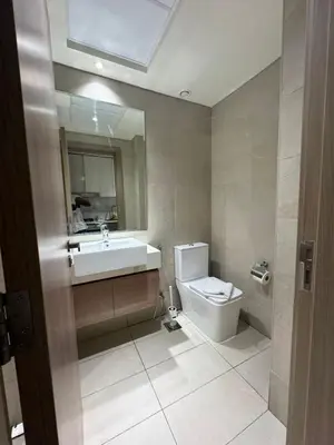 a bathroom with a sink and a toilet and a mirror at Iconic Studio in Azizi 48 with Pool and Gym in Dubai