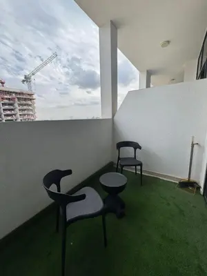 two chairs and tables in a room with a window at Iconic Studio in Azizi 48 with Pool and Gym in Dubai