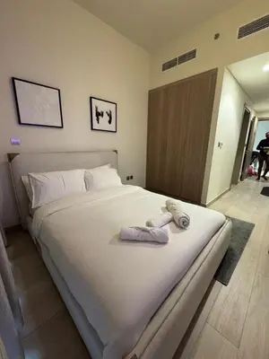 a bedroom with a large white bed with towels on it at Iconic Studio in Azizi 48 with Pool and Gym in Dubai