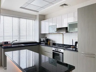 a kitchen with a black counter top and white cabinets at Blissful Escape 2 BDR In Bayz-19 in Dubai
