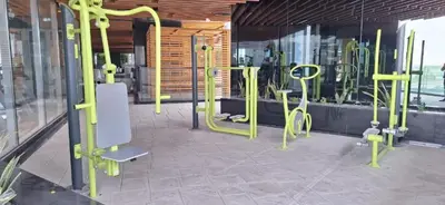 a gym with yellow exercise equipment in a room at Blissful Escape 2 BDR In Bayz-19 in Dubai