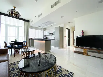 a living room with a large television and a table at Blissful Escape 2 BDR In Bayz-19 in Dubai