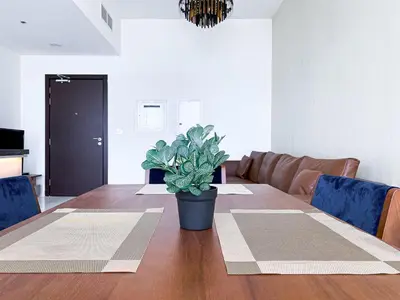 a dining room table with a potted plant on it at Blissful Escape 2 BDR In Bayz-19 in Dubai