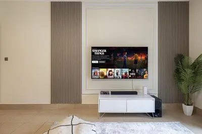 a living room with a tv on a wall at Dubai Icon Suite at Miska 2 in Dubai