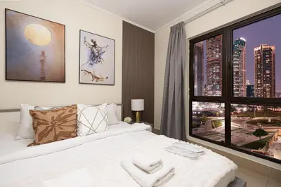 a bedroom with a white bed and a large window at Dubai Icon Suite at Miska 2 in Dubai