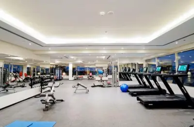 a gym with a large room with treadmills and machines at Vogue Sports City Hera Tower Near First Avenue Mall, Studio Apartment with Balcony, Canal and City View, Access to all Amenities in Dubai