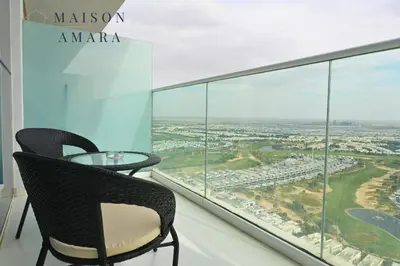 a balcony with a table and chairs and a view at Modern Luxury Studio Damac Hills With Golf View in Dubai